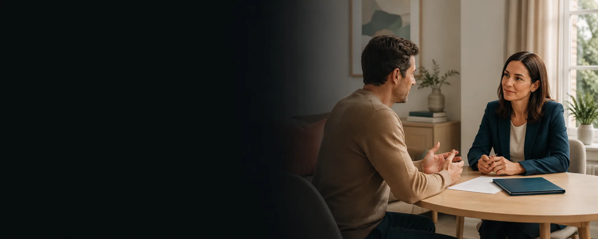 A solicitor and a client talking across a table in a calm, domestic meeting room