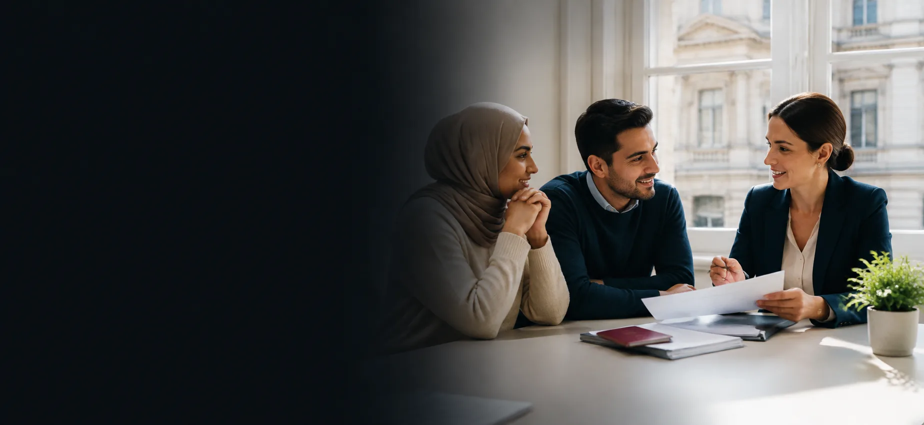 A couple reviewing immigration paperwork with their solicitor at a sunlit office table